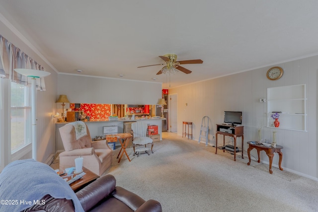 carpeted living room with ceiling fan and ornamental molding