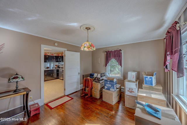 interior space featuring baseboards, wood finished floors, and crown molding