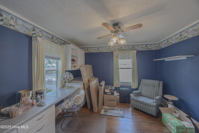 office space featuring crown molding, ceiling fan, built in desk, wood finished floors, and a textured ceiling