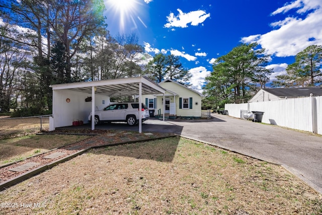 view of front of house with an attached carport, driveway, and fence