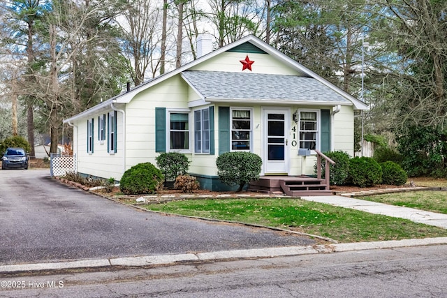 view of front of home with driveway and roof with shingles