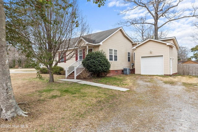 view of side of property featuring dirt driveway, fence, central air condition unit, a lawn, and an outdoor structure