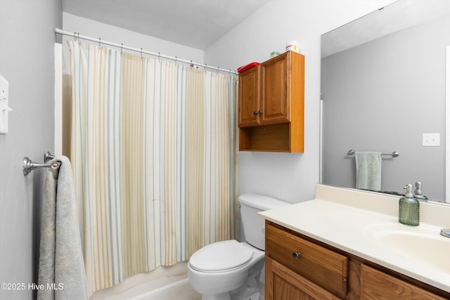 bathroom featuring toilet, vanity, and a shower with curtain