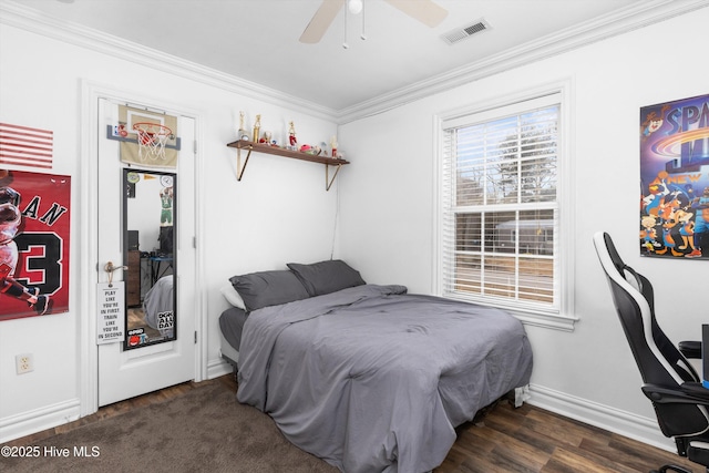 bedroom with visible vents, a ceiling fan, wood finished floors, crown molding, and baseboards