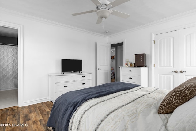 bedroom featuring a closet, baseboards, dark wood-style floors, and ornamental molding