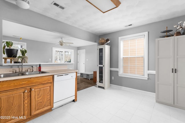 kitchen featuring light countertops, visible vents, white dishwasher, and a sink