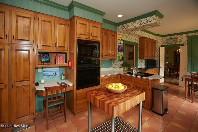 kitchen featuring light tile patterned floors, wallpapered walls, a peninsula, ornamental molding, and black appliances