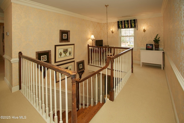 staircase with wallpapered walls and ornamental molding