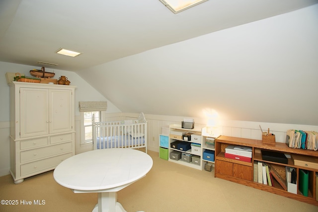 recreation room featuring lofted ceiling, visible vents, and light carpet