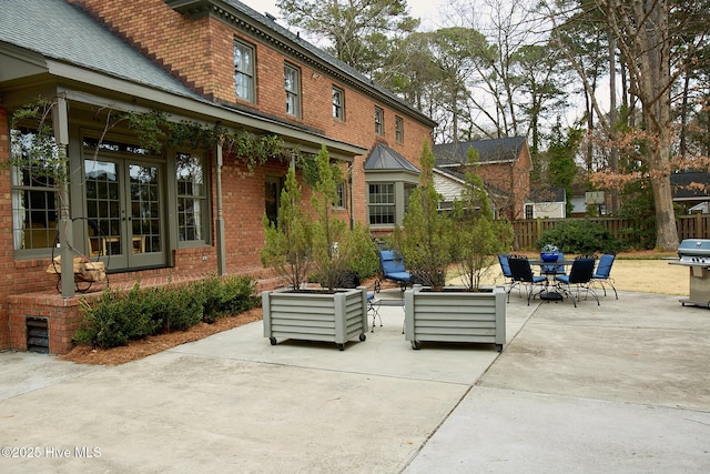 view of patio / terrace with french doors, grilling area, and fence