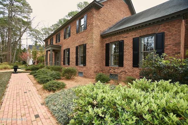 view of property exterior featuring crawl space and brick siding