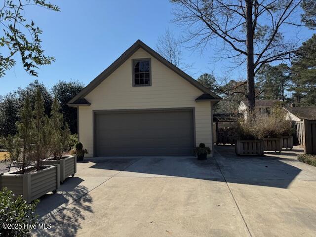 exterior space featuring a detached garage, an outdoor structure, and fence