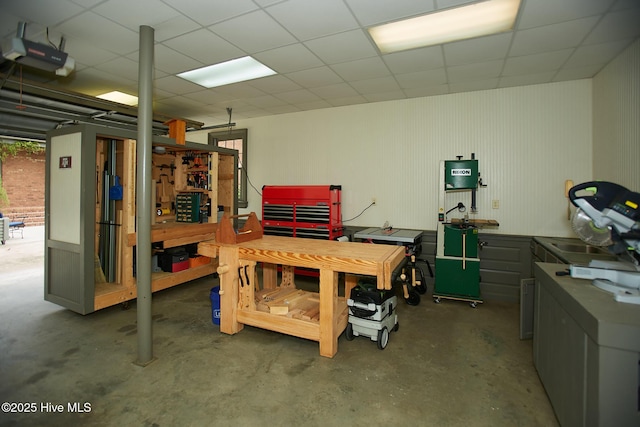 interior space with a drop ceiling and a workshop area