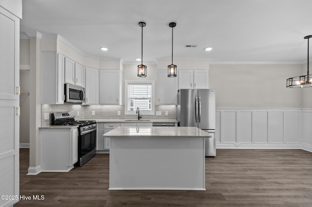 2366 Great Laurel Ct, Greenville, NC 27834 - kitchen with appliances with stainless steel finishes, a sink, ornamental molding, tasteful backsplash, and a kitchen island