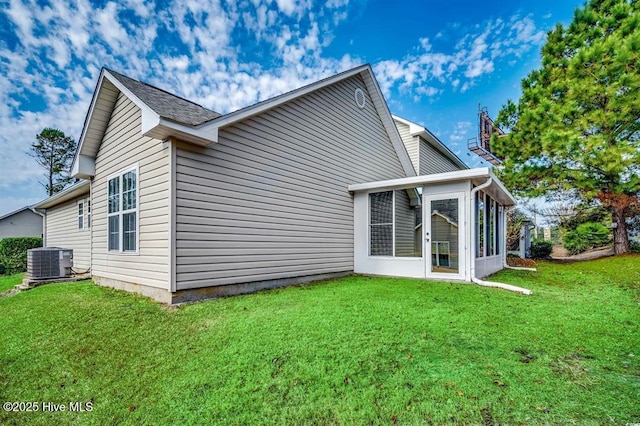 back of property with cooling unit, a lawn, and a sunroom