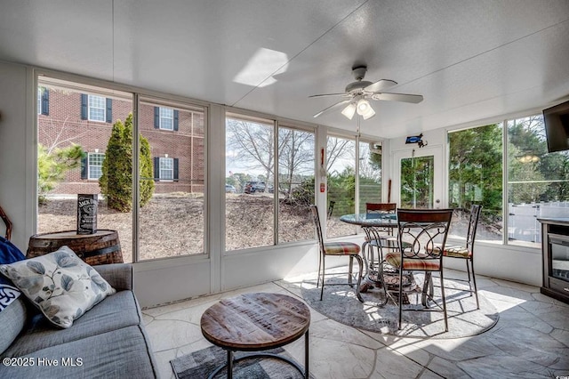 sunroom / solarium featuring ceiling fan