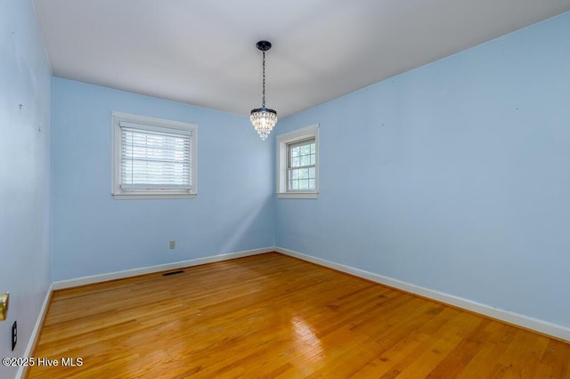 5218 Springwood Dr, Trent Woods, NC 28562 - spare room with baseboards, an inviting chandelier, visible vents, and light wood-type flooring