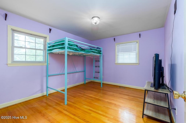 5218 Springwood Dr, Trent Woods, NC 28562 - unfurnished bedroom featuring light wood-style floors, baseboards, and multiple windows