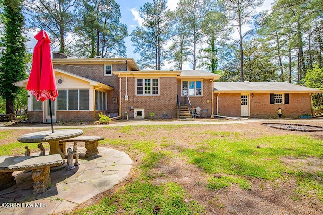 5218 Springwood Dr, Trent Woods, NC 28562 - rear view of house featuring brick siding, a chimney, and entry steps