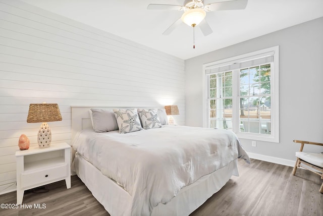 bedroom with ceiling fan, baseboards, and wood finished floors