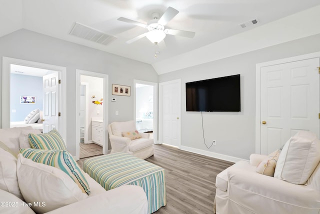 living room with visible vents, light wood-style flooring, a ceiling fan, and vaulted ceiling