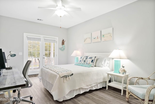 bedroom featuring a ceiling fan, wood finished floors, visible vents, access to exterior, and french doors