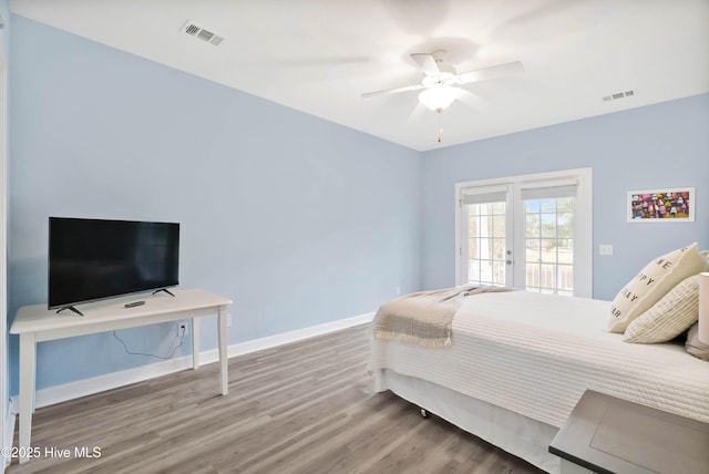 bedroom featuring access to outside, visible vents, baseboards, and wood finished floors