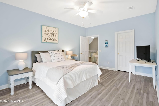 bedroom with ceiling fan, visible vents, light wood-type flooring, and baseboards