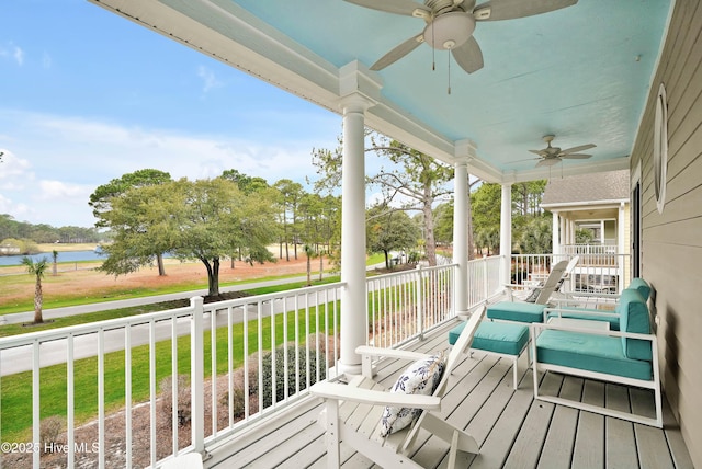 wooden deck featuring a yard, a water view, a porch, and ceiling fan