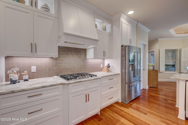 2184 Villamar Dr, Leland, NC 28451 - kitchen with stainless steel appliances, custom exhaust hood, ornamental molding, and white cabinets
