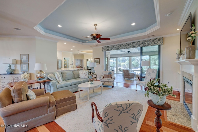 2184 Villamar Dr, Leland, NC 28451 - living area featuring wood finished floors, a tray ceiling, recessed lighting, ornamental molding, and a glass covered fireplace