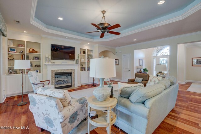 2184 Villamar Dr, Leland, NC 28451 - living room featuring a fireplace with flush hearth, a raised ceiling, visible vents, and wood finished floors