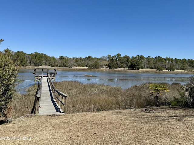 view of dock featuring a forest view and a water view