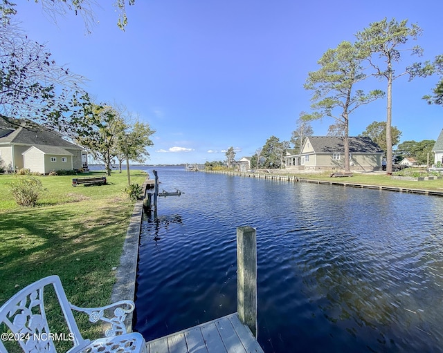 dock area with a yard and a water view