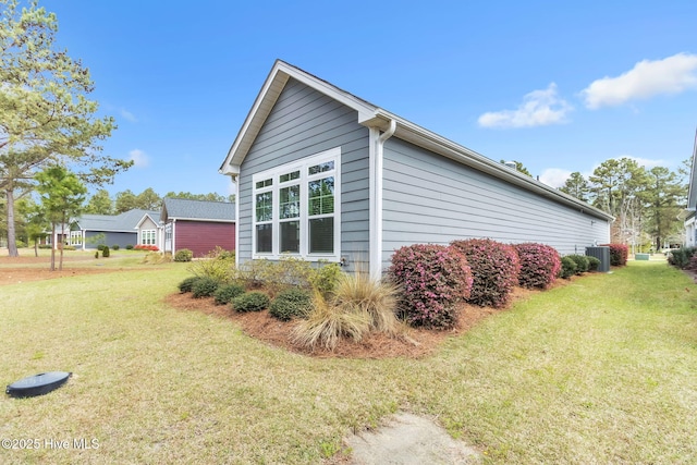 view of side of home featuring a yard and cooling unit