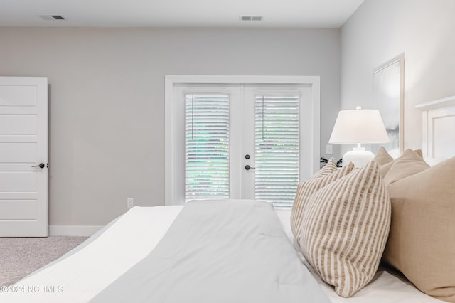 carpeted bedroom with access to exterior, baseboards, and visible vents