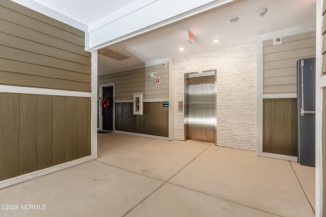 interior space with elevator and wood walls