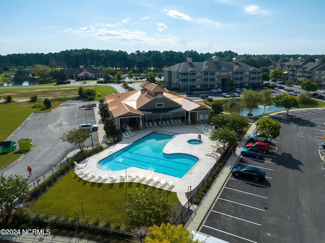 pool featuring a patio area, a water view, and a fenced backyard