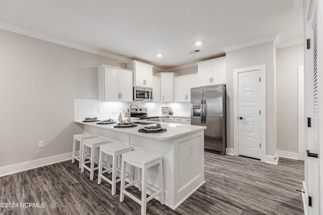 kitchen featuring appliances with stainless steel finishes, a peninsula, crown molding, white cabinets, and baseboards