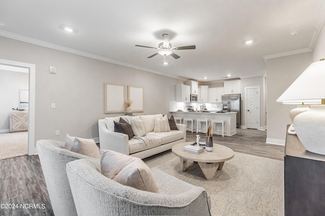 living area featuring crown molding, ceiling fan, baseboards, recessed lighting, and wood finished floors