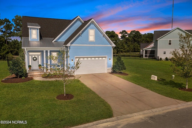 view of front facade with a porch, fence, concrete driveway, a front yard, and metal roof