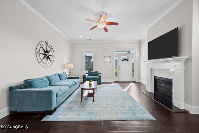 living area featuring a ceiling fan, wood finished floors, a fireplace, crown molding, and baseboards