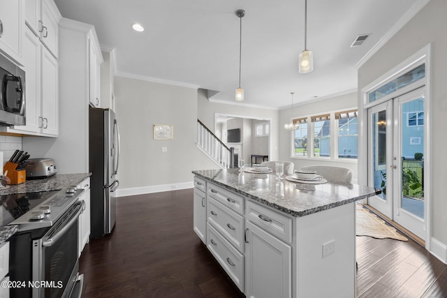 kitchen featuring visible vents, dark wood-type flooring, appliances with stainless steel finishes, crown molding, and light stone countertops