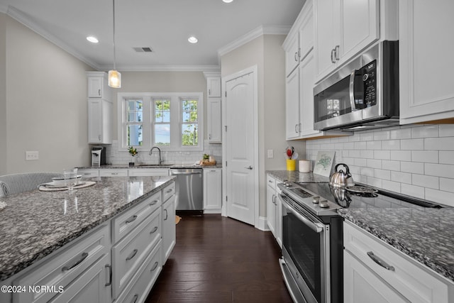 kitchen featuring white cabinets, appliances with stainless steel finishes, crown molding, and dark wood-style flooring