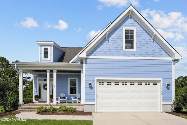 view of front of house with a garage, a porch, and concrete driveway