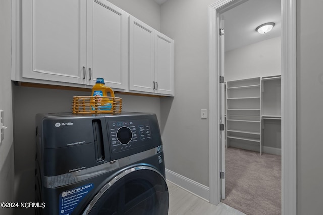 laundry room with washer / clothes dryer, cabinet space, baseboards, and light carpet