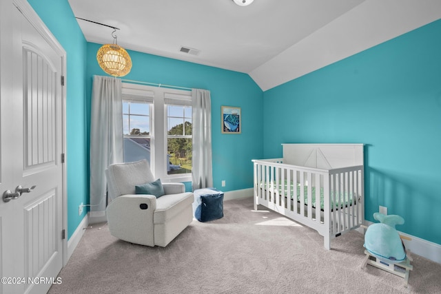 carpeted bedroom with a crib, vaulted ceiling, baseboards, and visible vents