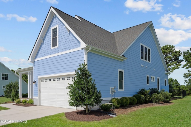 view of property exterior featuring driveway, an attached garage, a yard, and roof with shingles