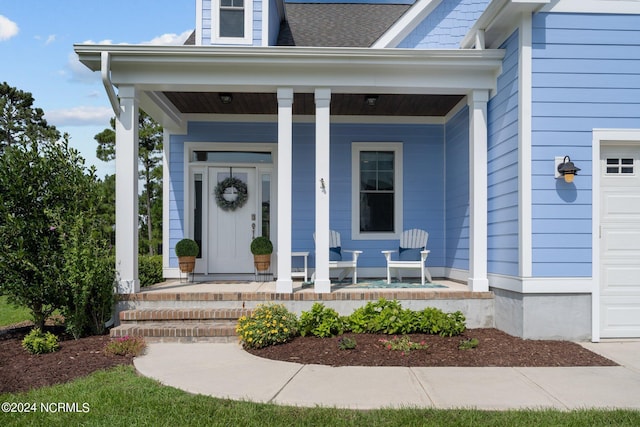 property entrance featuring a garage, a porch, and a shingled roof