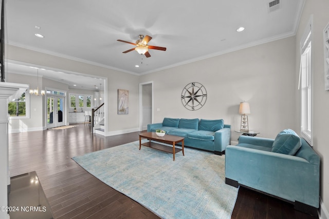 living room featuring wood finished floors, baseboards, visible vents, ornamental molding, and stairs